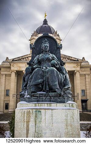 Stock Photograph - A sculpture of Queen Victoria with the Manitoba Legislative Building in the background with a statue of the Golden Boy on top; Winnipeg, Manitoba, Canada. Fotosearch