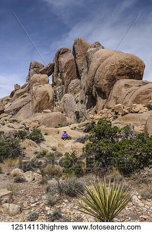 Stock Photograph - A senior woman in lotus pose in Joshua Tree National Park; California, United States of America. Fotosearch