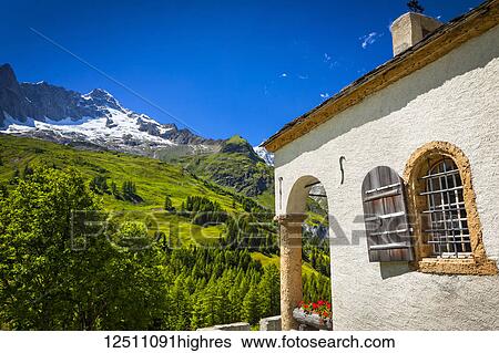 Stock Photograph - A small chapel at Ferret under blue sky; Ferret, Val Ferret, Switzerland. Fotosearch