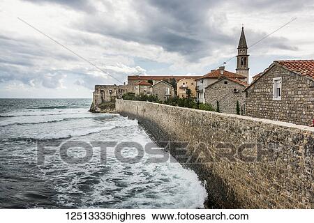 A stone wall lining the shoreline with buildings and a church tower; Budva, Opstina Budva, Monte View Large Photo Image Stock Photograph - A stone wall lining the shoreline with buildings and a church tower; Budva, Opstina Budva, Monte. Fotosearch