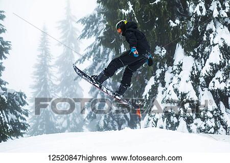 Stock Photograph - A teenage boy snowboarding on Mount Seymore, North Vancouver; Vancouver, British Columbia, Canada. Fotosearch