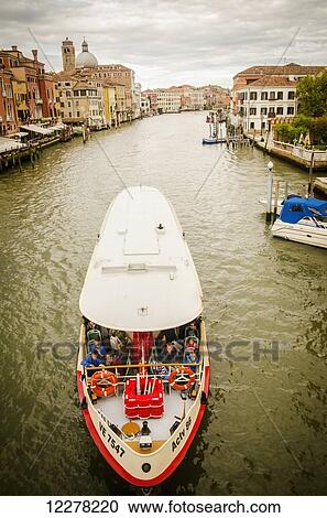 Stock Image - A tour boat makes it's way down the Grand Canal; Venice, Italy. Fotosearch