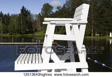 Stock Photograph - A white, wooden lifeguard chair at a lake at Lakeside Bible Camp; Whidbey Island, Washington, United States of America. Fotosearch