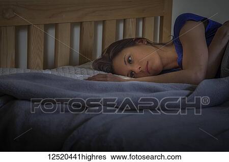 A woman lying on her bed with her eyes open; Connecticut, United States of America View Large Photo Image Stock Photograph - A woman lying on her bed with her eyes open; Connecticut, United States of America. Fotosearch
