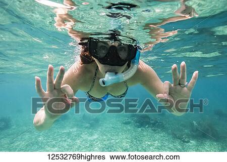 A woman snorkelling and making the 'okay' sign with her hands, Belize Barrier Reef; Belize View Large Photo Image Stock Photograph - A woman snorkelling and making the 'okay' sign with her hands, Belize Barrier Reef; Belize. Fotosearch
