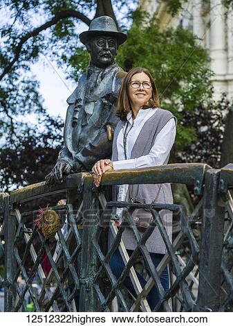 Stock Photograph - A woman stands beside the Monument of Imre Nagy in Martyrs Square; Budapest, Budapest, Hungary. Fotosearch