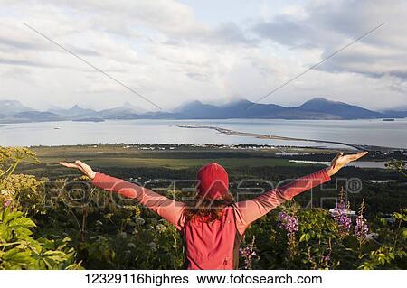 A woman stands looking out over Homer Spit, Kachemak Bay and the Kenai Mountains with arms outstretched in awe; Homer, Alaska, United States of America View Large Photo Image Stock Photograph - A woman stands looking out over Homer Spit, Kachemak Bay and the Kenai Mountains with arms outstretched in awe; Homer, Alaska, United States of America. Fotosearch