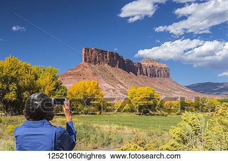 A woman taking a cell phone photo of the rock formation 'the Palisade'; Gateway, Colorado, United States of America View Large Photo Image Stock Photograph - A woman taking a cell phone photo of the rock formation 'the Palisade'; Gateway, Colorado, United States of America. Fotosearch