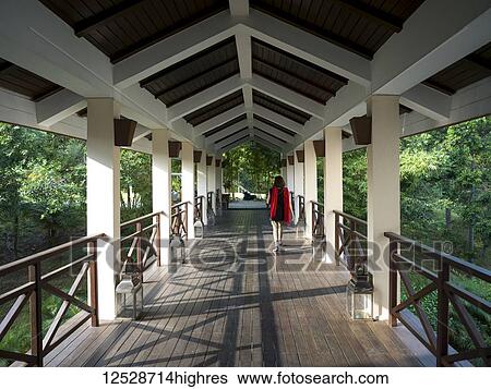A woman walks down an open-air corridor, Ananda Hotel and Spa; Uttarakhand, India View Large Photo Image Stock Photograph - A woman walks down an open-air corridor, Ananda Hotel and Spa; Uttarakhand, India. Fotosearch