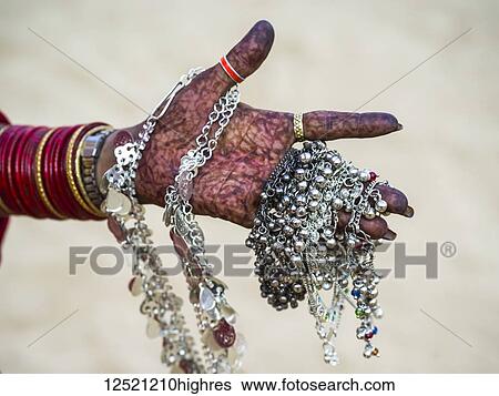 A woman's hand covered in henna body art and holding silver jewelry; Jaisalmer, Rajasthan, India View Large Photo Image Stock Photograph - A woman's hand covered in henna body art and holding silver jewelry; Jaisalmer, Rajasthan, India. Fotosearch