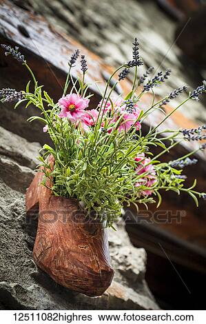 A wooden shoe carved flower pot along ancient cobblestone streets of Dolonne, near Courmayeur; Aosta Valley, Italy View Large Photo Image Stock Photograph - A wooden shoe carved flower pot along ancient cobblestone streets of Dolonne, near Courmayeur; Aosta Valley, Italy. Fotosearch