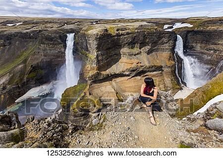 A young asian female hiker poses for a portrait on the edge of a stunning double waterfall valley landscape known as Haifoss; Iceland View Large Photo Image Stock Photograph - A young asian female hiker poses for a portrait on the edge of a stunning double waterfall valley landscape known as Haifoss; Iceland. Fotosearch