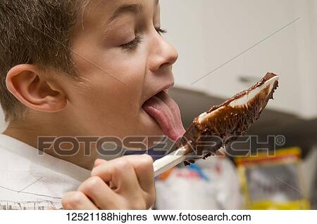 A young boy licks the chocolate from the spatula after making fudge; Langley, British Columbia, Canada View Large Photo Image Stock Photograph - A young boy licks the chocolate from the spatula after making fudge; Langley, British Columbia, Canada. Fotosearch