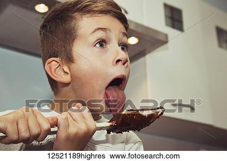 A young boy licks the chocolate from the spatula after making fudge; Langley, British Columbia, Canada View Large Photo Image Stock Photograph - A young boy licks the chocolate from the spatula after making fudge; Langley, British Columbia, Canada. Fotosearch