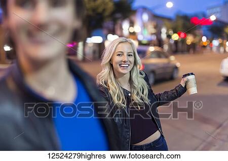 A young couple being playful on the sidewalk beside a city street at dusk; Edmonton, Alberta, Canada View Large Photo Image Stock Photograph - A young couple being playful on the sidewalk beside a city street at dusk; Edmonton, Alberta, Canada. Fotosearch