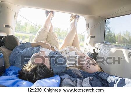 A young couple lays in the back of their vehicle during a road trip talking and laughing together; Edmonton, Alberta, Canada View Large Photo Image Stock Photograph - A young couple lays in the back of their vehicle during a road trip talking and laughing together; Edmonton, Alberta, Canada. Fotosearch