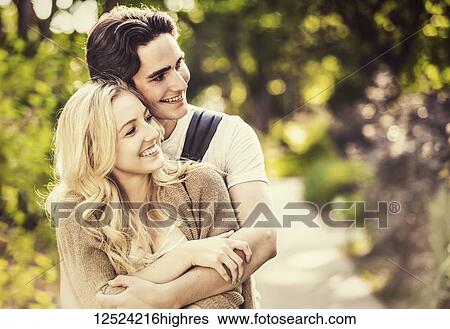 A young couple shares a romantic moment together in an embrace while outside on the university campus; Edmonton, Alberta, Canada View Large Photo Image Stock Photograph - A young couple shares a romantic moment together in an embrace while outside on the university campus; Edmonton, Alberta, Canada. Fotosearch