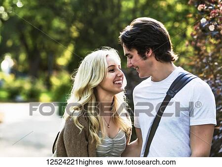 A young couple shares a romantic moment together contemplating a kiss while walking through a university campus; Edmonton, Alberta, Canada View Large Photo Image Stock Photograph - A young couple shares a romantic moment together contemplating a kiss while walking through a university campus; Edmonton, Alberta, Canada. Fotosearch