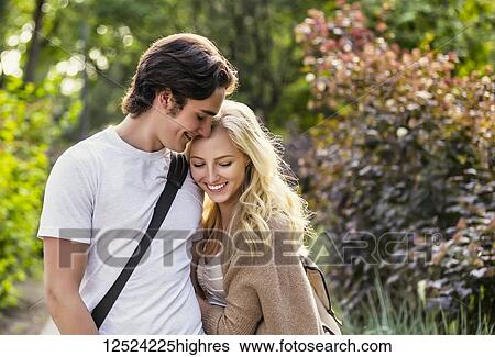Stock Photograph - A young couple shares a romantic moment together on the university campus; Edmonton, Alberta, Canada. Fotosearch