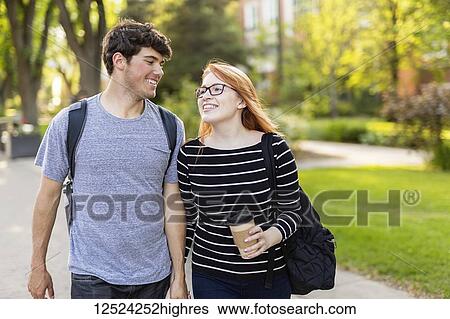 A young couple walking and holding hands while walking through a university campus; Edmonton, Alberta, Canada View Large Photo Image Stock Photograph - A young couple walking and holding hands while walking through a university campus; Edmonton, Alberta, Canada. Fotosearch