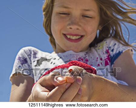 A young girl shows off a ladybug (Coccinellidae) she caught and is holding on her thumb; Destin, Florida, United States of America View Large Photo Image Stock Photograph - A young girl shows off a ladybug (Coccinellidae) she caught and is holding on her thumb; Destin, Florida, United States of America. Fotosearch