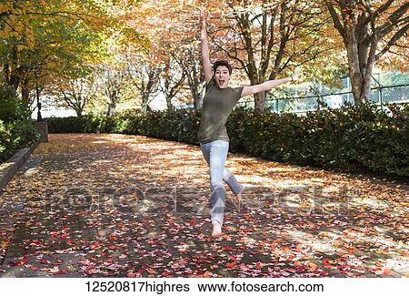 A young woman dances on a path in a park in autumn; New Westminster, British Columbia, Canada View Large Photo Image Stock Photograph - A young woman dances on a path in a park in autumn; New Westminster, British Columbia, Canada. Fotosearch