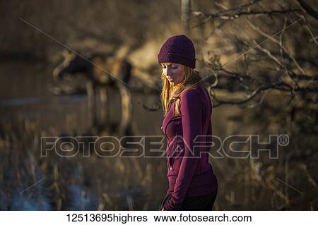 A young woman stands in the foreground with a cow moose (alces alces) in the pond in the background; Anchorage, Alaska, United States of America View Large Photo Image Stock Photograph - A young woman stands in the foreground with a cow moose (alces alces) in the pond in the background; Anchorage, Alaska, United States of America. Fotosearch