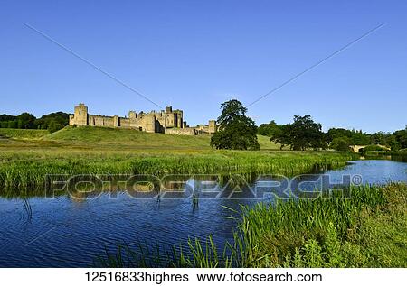 Stock Photograph - Alnwick Castle and Capability Brown parkland on the River Aln; Alnwick, Northumberland, England. Fotosearch