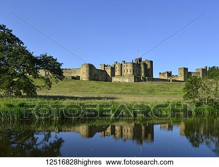 Stock Photograph - Alnwick Castle reflected on the River Aln; Alnwick, Northumberland, England. Fotosearch