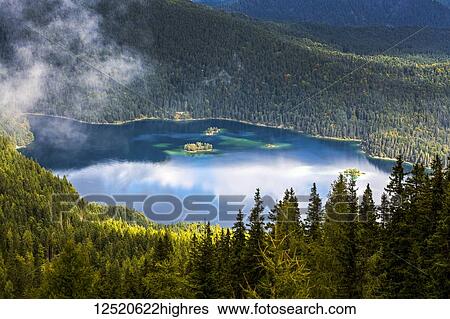 Alpine lake viewed from above and framed with tree covered mountain slopes; Grainau, Bavaria, Germany View Large Photo Image Stock Photograph - Alpine lake viewed from above and framed with tree covered mountain slopes; Grainau, Bavaria, Germany. Fotosearch