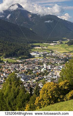 Stock Photograph - Alpine village in the valley with mountains in the background; San Candido, Bolzano, Italy. Fotosearch