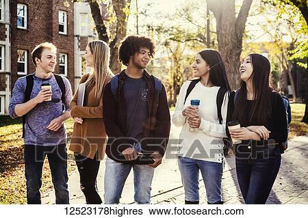 Stock Photograph - An ethnically diverse group of university students walk and talk together on the campus in autumn; Edmonton, Alberta, Canada. Fotosearch
