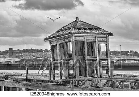 Stock Photograph - An old broken shed leaning to the side at a Liverpool dock; Liverpool, England. Fotosearch
