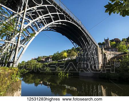 Stock Photograph - Arched iron bridge over a river; England. Fotosearch