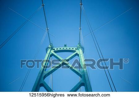 Stock Photograph - Architectural detail of the Lions Gate Bridge against a blue sky; Vancouver, British Columbia, Canada. Fotosearch
