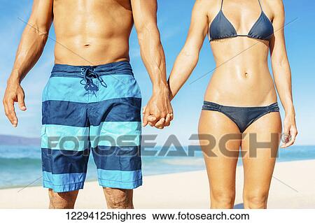 Attractive Fit Couple On The Beach In Swimwear Holding Hands View Large Photo Image Stock Photograph - Attractive Fit Couple On The Beach In Swimwear Holding Hands. Fotosearch