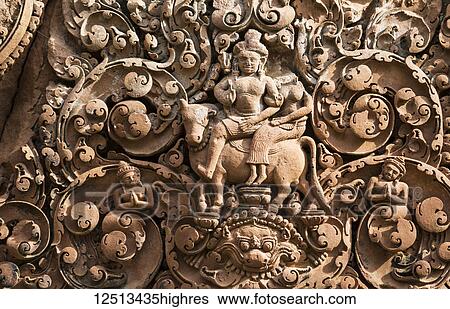 Stock Photograph - Bas-relief of Shiva riding Nandi on a pediment of Banteay Srei; Angkor, Siem Reap, Cambodia. Fotosearch