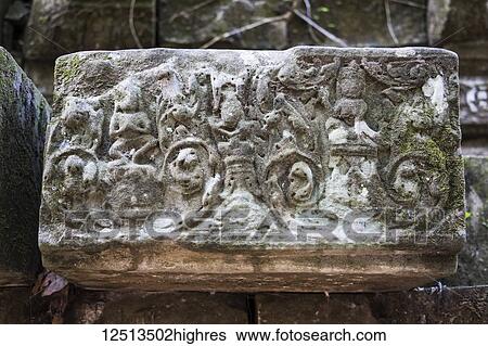Stock Photograph - Bas-relief on a fallen stone in the ruins of the Khmer temple of Beng Meala, Siem Reap, Cambodia. Fotosearch