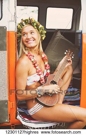 Stock Photograph - Beach Lifestyle, Beautiful Surfer Girl With Ukulele And Classic Vintage Surf Van On The Beach At Sunset. Fotosearch