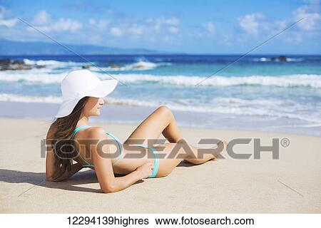 Stock Photograph - Beach Vacation. Beautiful Young Woman In Sun Hat Relaxing On The Beach.. Fotosearch