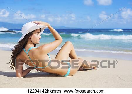 Stock Photograph - Beach Vacation. Beautiful Young Woman In Sun Hat Relaxing On The Beach.. Fotosearch