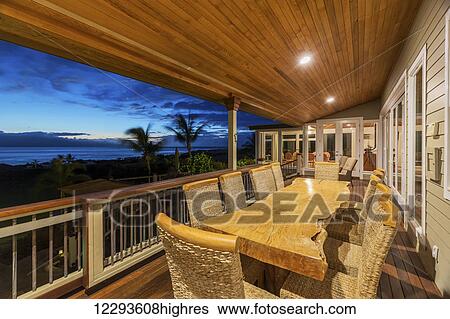 Stock Photograph - Beautiful Home Exterior Patio Deck And Dining Table With Sunset View. Fotosearch
