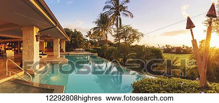 Stock Photograph - Beautiful Luxury Home With Swimming Pool At Sunset. Fotosearch