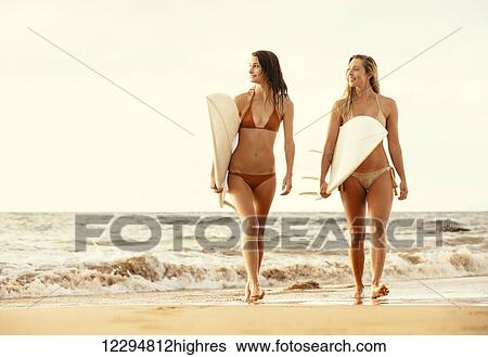 Beautiful Surfer Girls Walking On The Beach At Sunset View Large Photo Image Stock Photograph - Beautiful Surfer Girls Walking On The Beach At Sunset. Fotosearch
