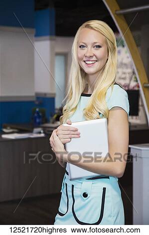 Beautiful young millennial business woman with long blond hair posing for the camera in the workplace; Edmonton, Alberta, Canada View Large Photo Image Stock Photograph - Beautiful young millennial business woman with long blond hair posing for the camera in the workplace; Edmonton, Alberta, Canada. Fotosearch