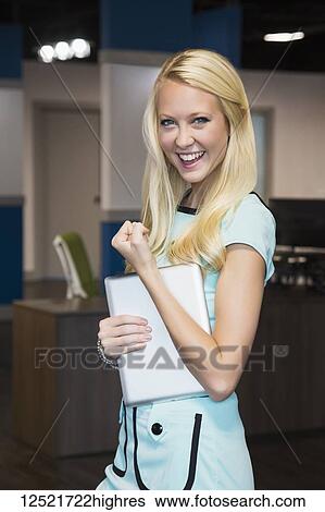 Beautiful young millennial business woman with long blond hair posing for the camera in the workplace, giving a sign of success; Edmonton, Alberta, Canada View Large Photo Image Stock Photograph - Beautiful young millennial business woman with long blond hair posing for the camera in the workplace, giving a sign of success; Edmonton, Alberta, Canada. Fotosearch