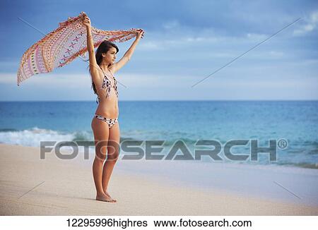 Beautiful Young Woman With Scarf On The Beach At Sunset. Travel And Vacation Concept. Fashion Lifestyle. View Large Photo Image Stock Photograph - Beautiful Young Woman With Scarf On The Beach At Sunset. Travel And Vacation Concept. Fashion Lifestyle.. Fotosearch