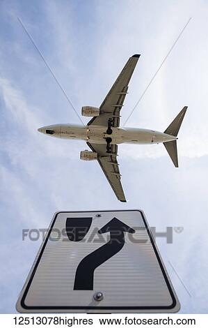 Stock Photograph - Boeing 737-7CT aircraft on final approach passes over a road sign, Mississauga, Ontario, Canada. Fotosearch