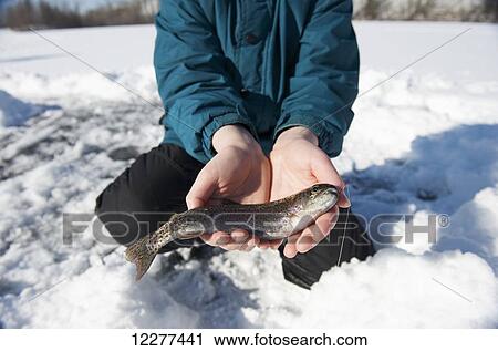 Stock Image - Boy ice fishing on Matanuska Lake in the Matanuska Valley north of Anchorage, Southcentral Alaska. Fotosearch