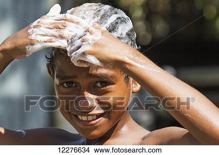 Picture - Boy washing his hair; Manatuto, East Timor. Fotosearch